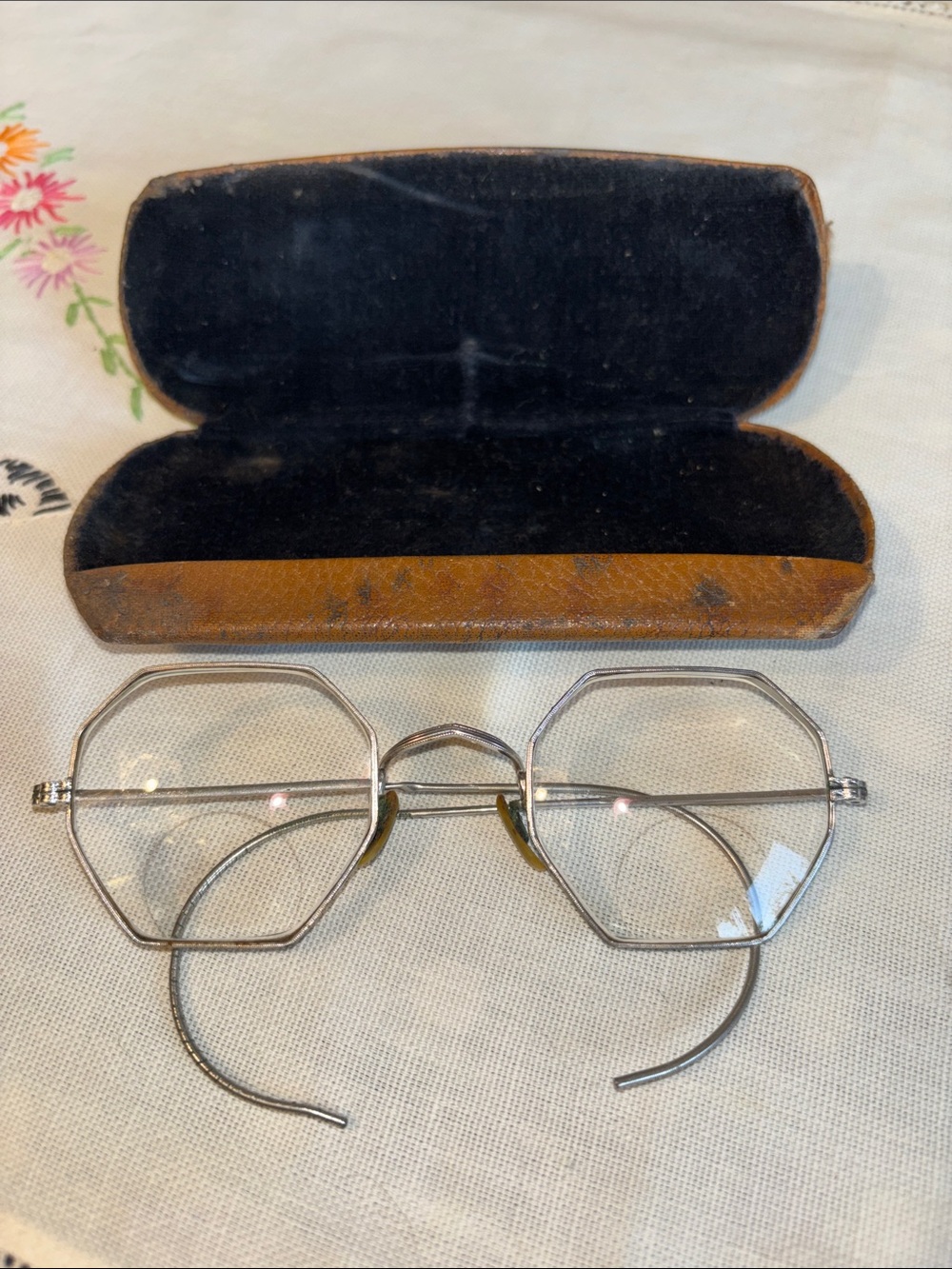 EUC VINTAGE octagonal wire-rimmed spectacles resting inside a weathered, brown l